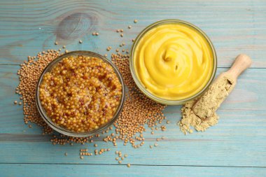 Açık mavi ahşap masa üzerinde farklı hardal türleri, düz yatıyordu.