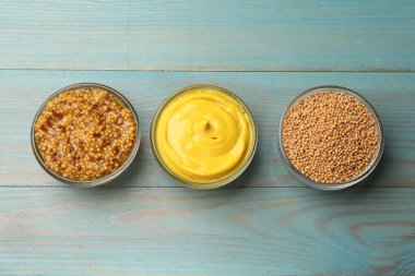 Açık mavi ahşap masa üzerinde farklı hardal türleri, düz yatıyordu.