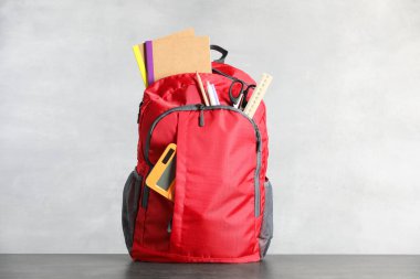 Kırmızıda kırtasiye malzemesi olan kırmızı sırt çantası