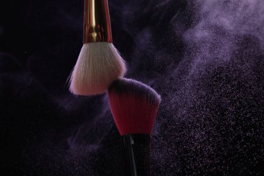 Siyah arka planda mor göz farlı makyaj fırçaları, yakın plan