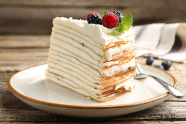 Tahta masada servis edilen meyveli lezzetli krep keki, yakın plan.