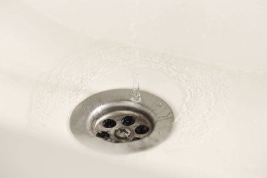 Su tasarrufu konsepti. Su lavaboya akıyor, kapatılıyor.