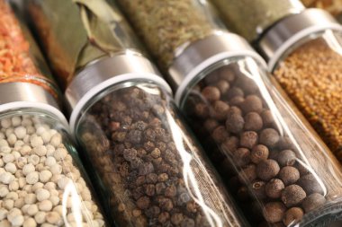 Arka plan olarak cam kavanozlardaki farklı baharatlar, yakın plan
