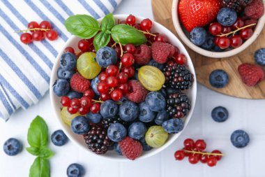 Farklı olgun, sulu böğürtlen ve fesleğen beyaz fayanslı masada, düz bir şekilde yatıyordu.