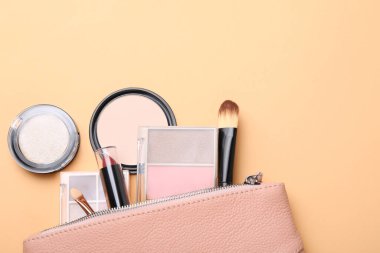 Renkli göz farı paletleri, diğer kozmetik ürünler, makyaj fırçası, bej arka planda aplikatör ve güzellik çantası, düz yatak. Metin için boşluk