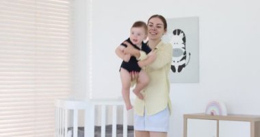 Anne evde küçük sevimli bebeğiyle eğleniyor.