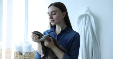 Pencerenin yanında temiz çamaşırları olan bir kadın.