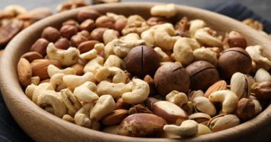 Masada farklı fındıkların karışımı, yakın plan. Kamera sağa hareket ediyor