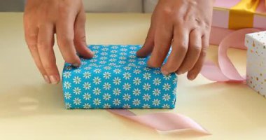 Masada hediye paketini açan kadın, yakın plan.