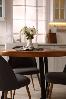 Dining table, chairs and floral decor in kitchen. Interior design