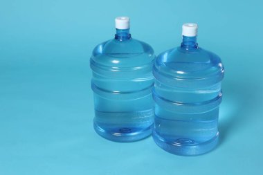 Açık mavi zemin üzerinde su olan soğutucu şişeler. Metin için boşluk