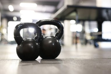 Spor salonunda yerde siyah çaydanlık, yakın plan. Metin için boşluk