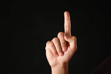 Siyah arkaplanda bir şeye dokunan adam, yakın plan