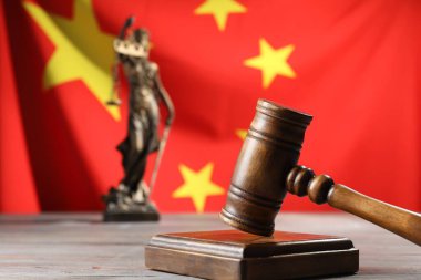 Yargıç tokmağı ve heykeli Çin bayrağına karşı ahşap masada, yakın plan. Metin için boşluk