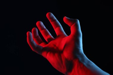 Siyah arka planda bir şey tutan adam, yakın plan.