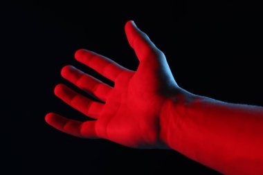 Siyah arka planda bir şey tutan adam, yakın plan.