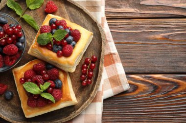 Böğürtlenli puf börekler ve ahşap masada nane şekeri, üst manzara. Metin için boşluk