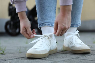 Dışarıdaki beyaz spor ayakkabılı kadın, yakın plan.