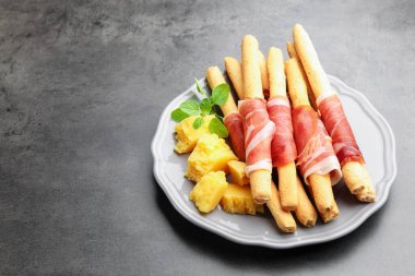 Grissini ekmeği, jambon ve peynirli gri masada. Metin için boşluk