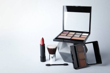 Beyaz arkaplanda göz falı paletleri, ruj ve fırçalar, metin için boşluk