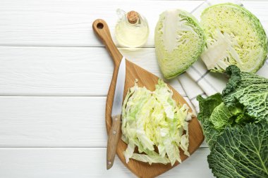 Taze kesilmiş Savoy lahanası ve bıçak beyaz masada, düz yerde. Metin için boşluk
