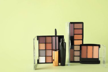 Soluk yeşil arka planda maskara ve göz falı.