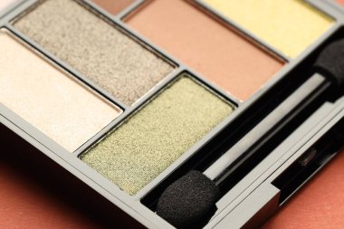 Mercan arka planda güzel bir göz falı ve fırça, yakın plan.