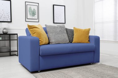Living room with blue sofa and pillows. Interior design