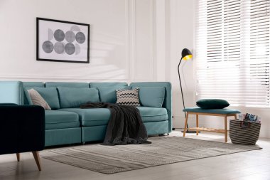 Açık mavi kanepesi ve diğer mobilyaları olan oturma odası. İç tasarım