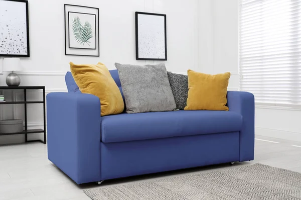Living room with blue sofa and pillows. Interior design
