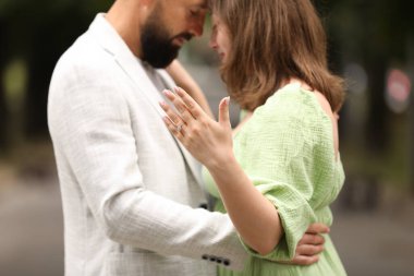 Evlilik teklifi yapıyor. Nişan yüzüğünü gösteren ve dışarıda nişanlısına sarılan bir kadın.