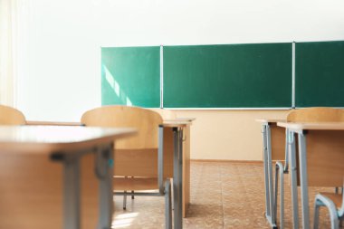 Sınıfta sandalyeli ve yeşil karatahtalı masalar