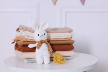 Temiz bebek kıyafetleri ve aksesuarlar beyaz masa içinde, yakın plan.