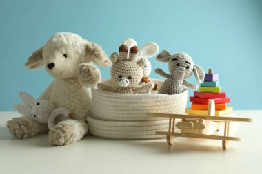 Beyaz masada açık mavi arka planda farklı sevimli oyuncaklar