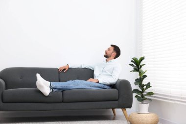 Evdeki kanepede dinlenen mutlu adam. Metin için boşluk