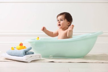 Evde küvette banyo yapan şirin bir bebek.