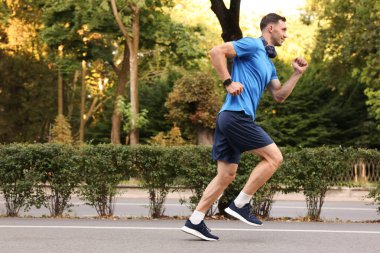 Spor giyimli bir adam açık havada koşuyor, mesaj için yer var.