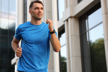 Spor giyimli bir adam açık havada koşuyor. Düşük açılı. Metin için boşluk