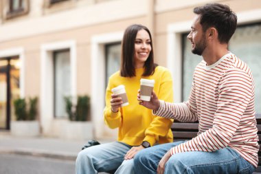 Paket kahve. Şehir caddesinde kağıt bardakta içki içen çift, mesaj için yer.