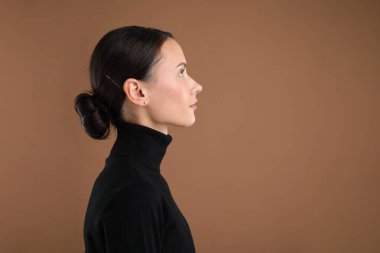 Kahverengi arka planda güzel bir kadının portresi. Metin için boşluk