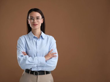 Kahverengi arka planda kendine güvenen bir iş kadınının portresi. Metin için boşluk