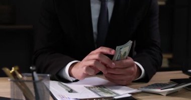 Ahşap masada dolar sayan adam, yakın plan.