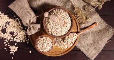 Yulaf taneleri ve çiçekleri ahşap masada, düz yerde. Kamera içeri giriyor.