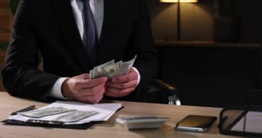 Ahşap masada dolar sayan adam, yakın plan.