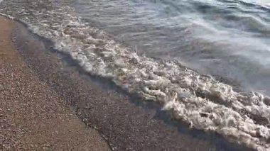 Güzel dalgalı deniz ve kumlu sahil, yakın çekim.