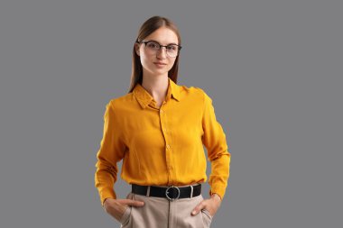 Gri arkaplanda kendine güvenen bir kadının portresi