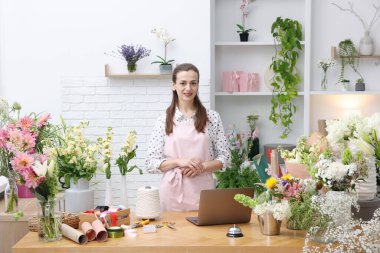 Dükkandaki ahşap masada çalışan profesyonel bir çiçekçi.
