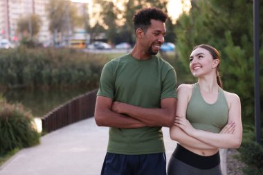 Gülümseyen koşucular dışarıda çapraz kollarla poz veriyorlar. Metin için boşluk