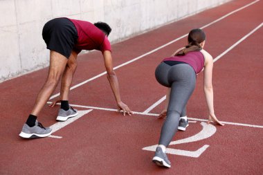 Stadyumda koşmak için başlangıç pozisyonunda bir çift var.