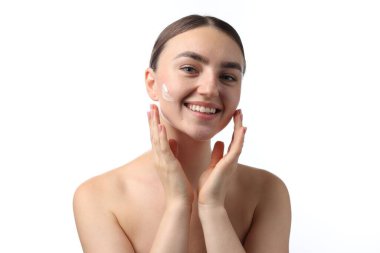 Beyaz arka planda krem sürmüş güzel bir kadın.